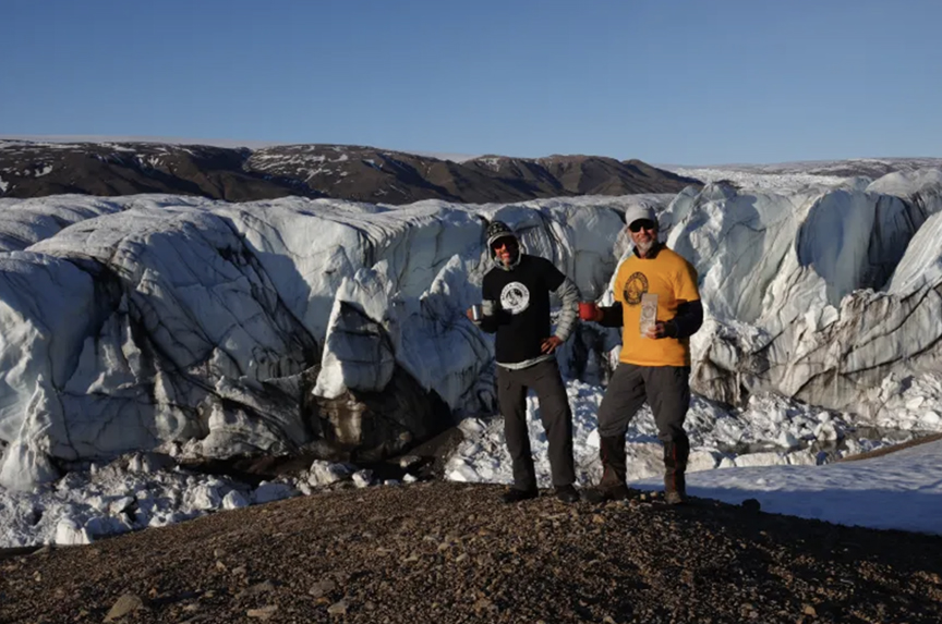 two guys standing in front of glacier