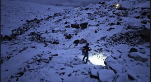 Andrews runs on a snowed up Everest Base Camp as night falls.