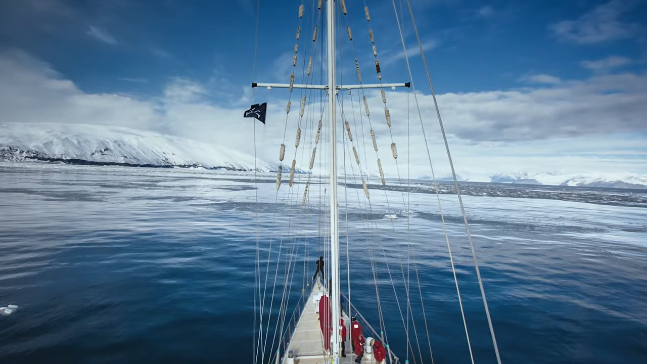 The bow of a ship, facing an icy cliff