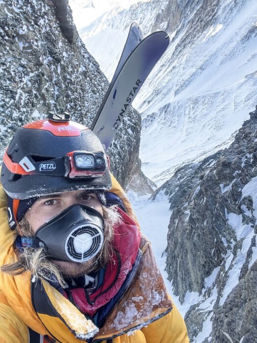 Close shot of Ziemski with an air-trimming mask while clmbing a couloir. 