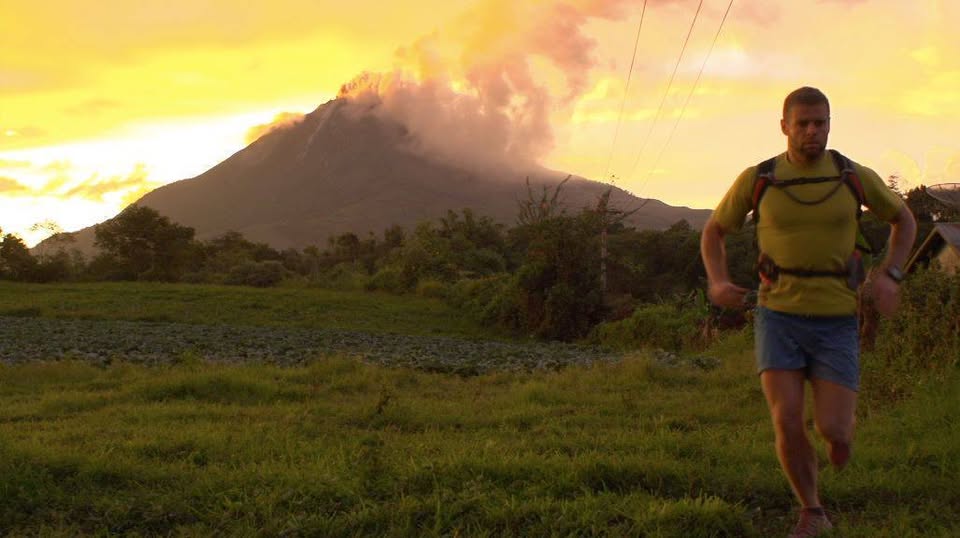 A man running, volcano in background