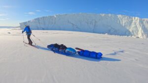 sledder beside iceberg
