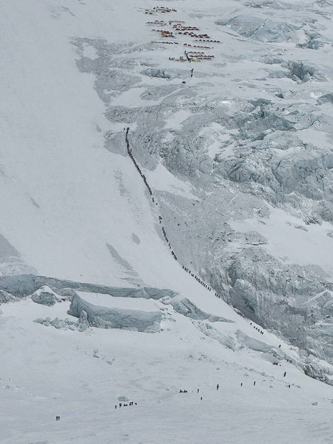 a line of climbers up a huge snow slope on Everest/Lhotse.