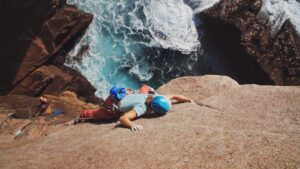 A woman climbing above the sea