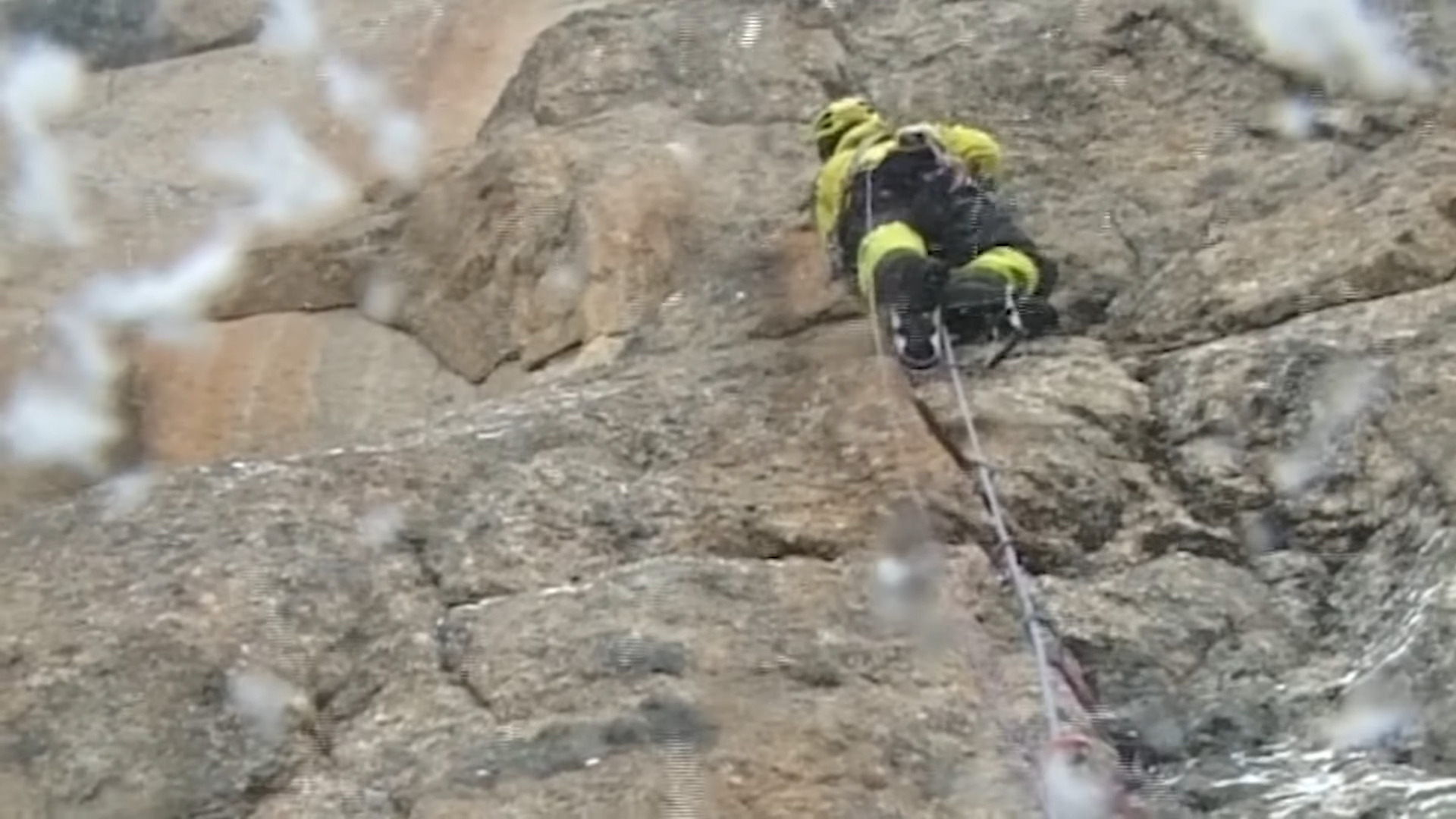 A man climbing while snow falls