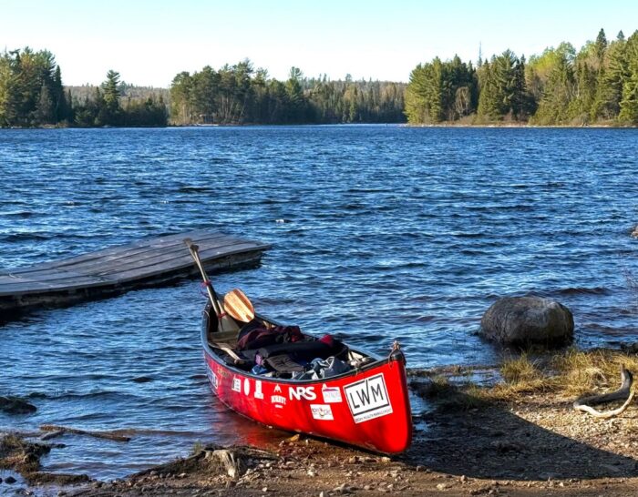 A red canoe on the shores of a lake in Canada