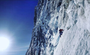 A climber on a vertical mixed face.