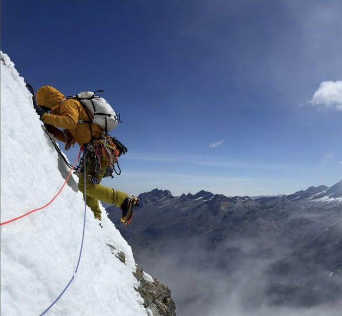 A climber on a steep snow ramp.