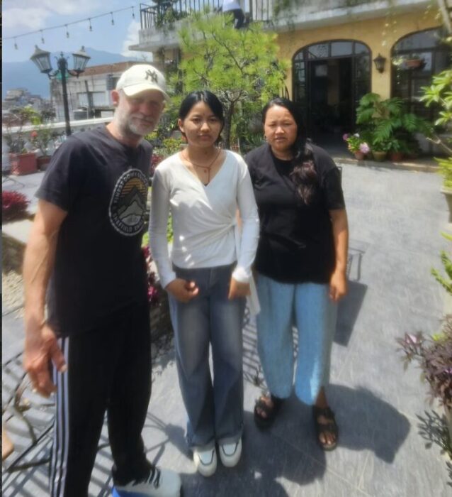 A British man and two Nepalese women at a terrace in Kathmandu. 