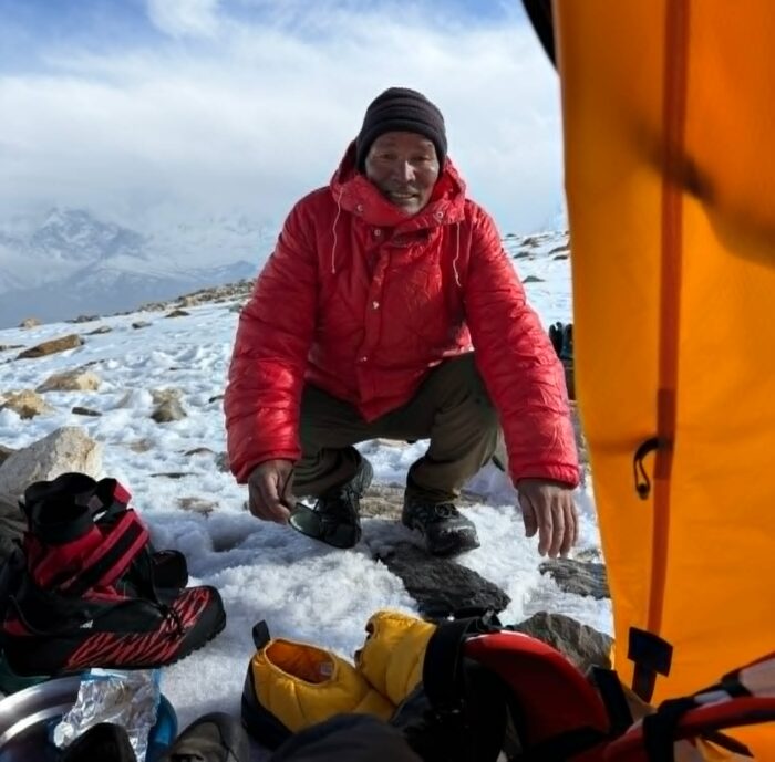 A sherpa at the gate of a tent.