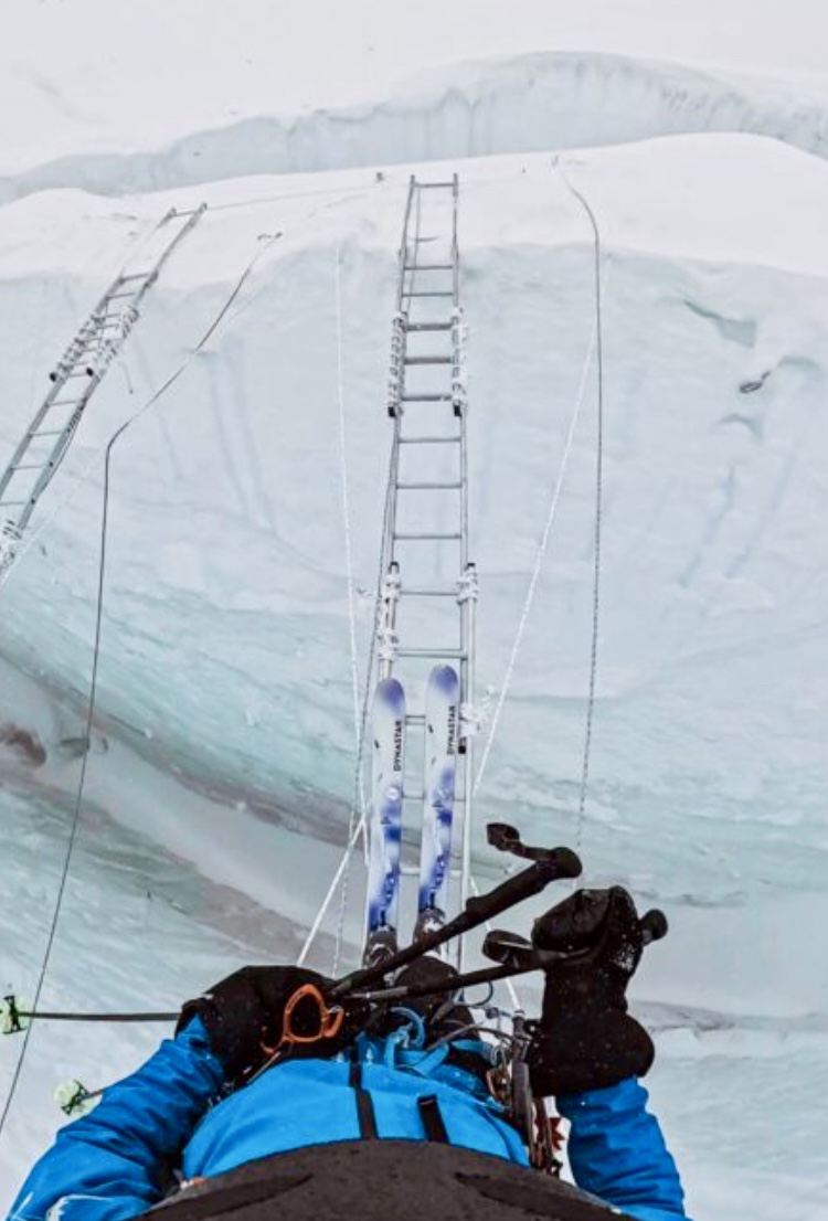 Bartek Ziemski crossing a ladder on skis at the Khumbu Icefall.