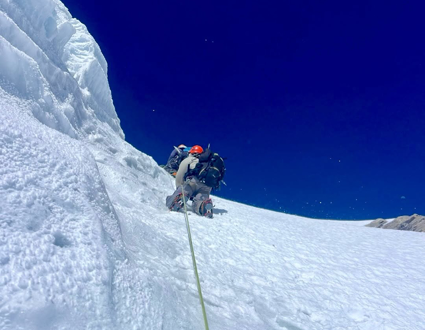 A climber reaching a col after overcoming a steep ice section.