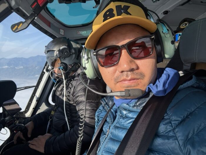 Close shot of a sherpa with headphones inside a helicopter