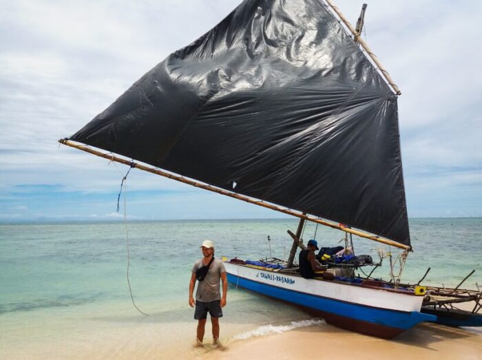 Danish adventurer standing next to his traditional sailing canoe in Papua New Guinea