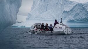 rowers next to iceberg