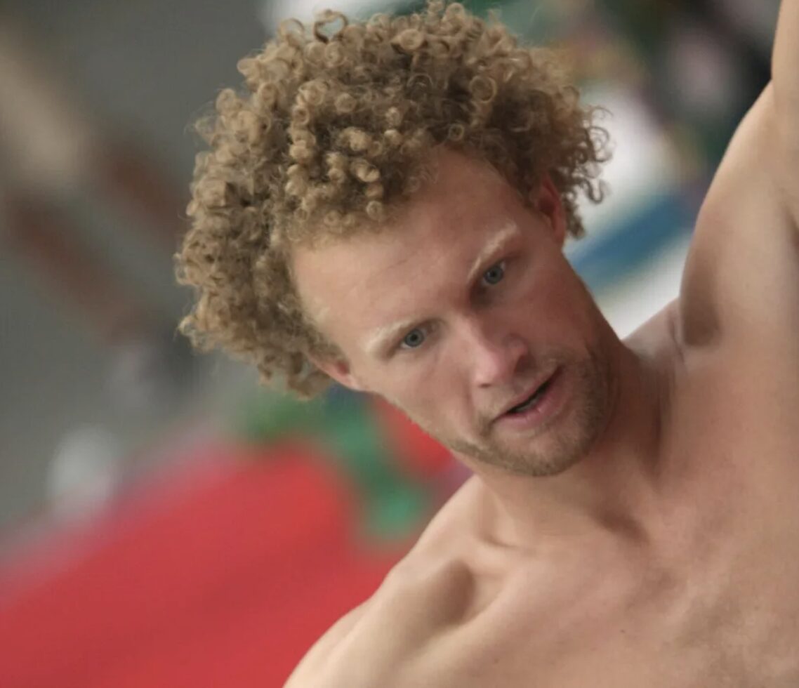 portrait of bare chested curly haired guy