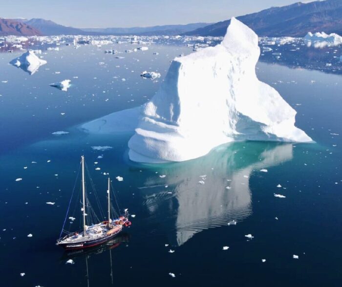 A sailboat in a fiord full of icebergs