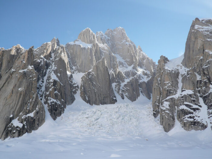 A mountain massif on glacial terrain with rock spires.