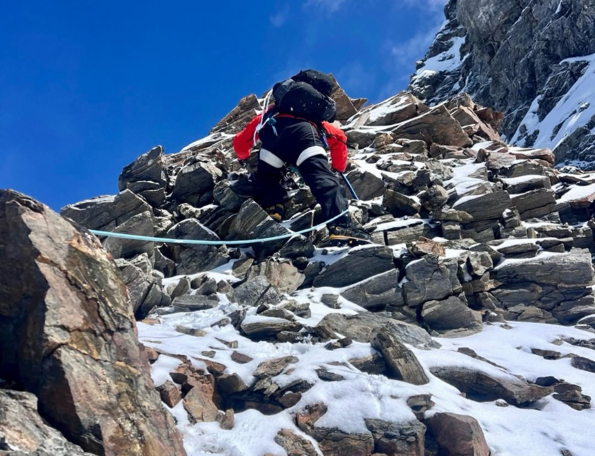 A climber roped up on a steep section of rotten rock.