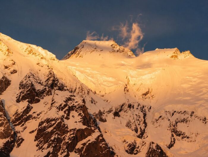 Nanga parbat's summit area snowed up and lit by dim light.