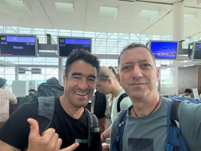 Two climbers smile at an airport on their way to Skardu, Pakistan.