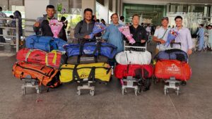 Sherpa climbers at the airport, with trolleys filled with duffel bags.