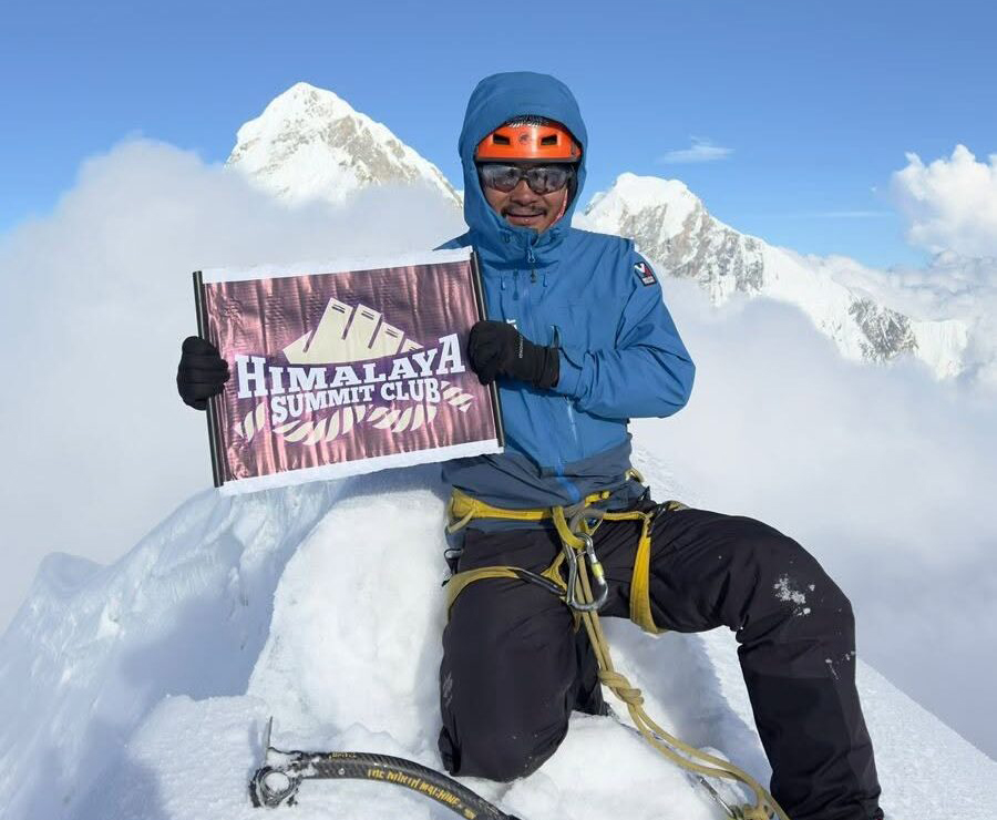 man on summit holding company flag