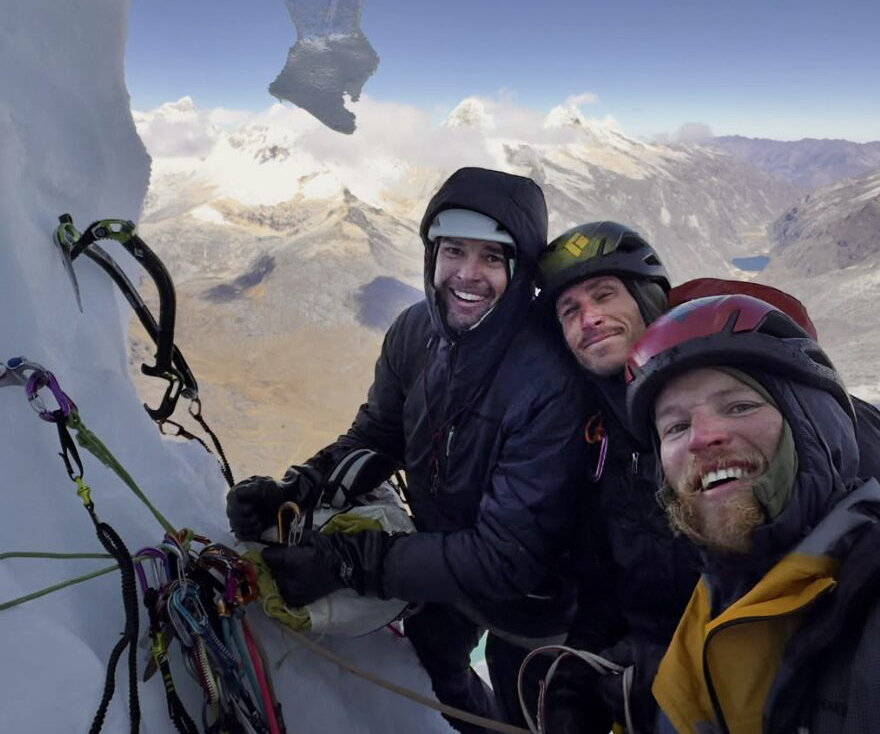3 climbers look at camera on ice pitch