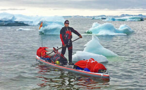man on stand-up paddleboard in ice-choked Arctic waters