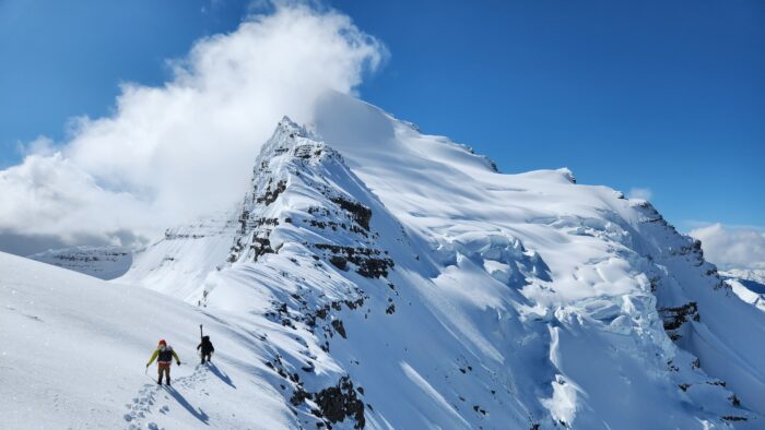 Two climbers walking on a snow covered ridge in the Canadian Rockies