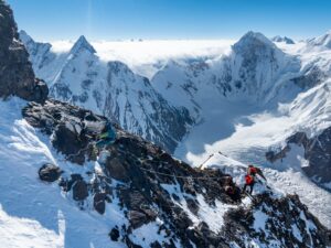 A climber on a ridge section, peaks and glaciers
