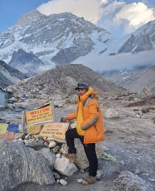 mountaineer standing beside cairn in base camp