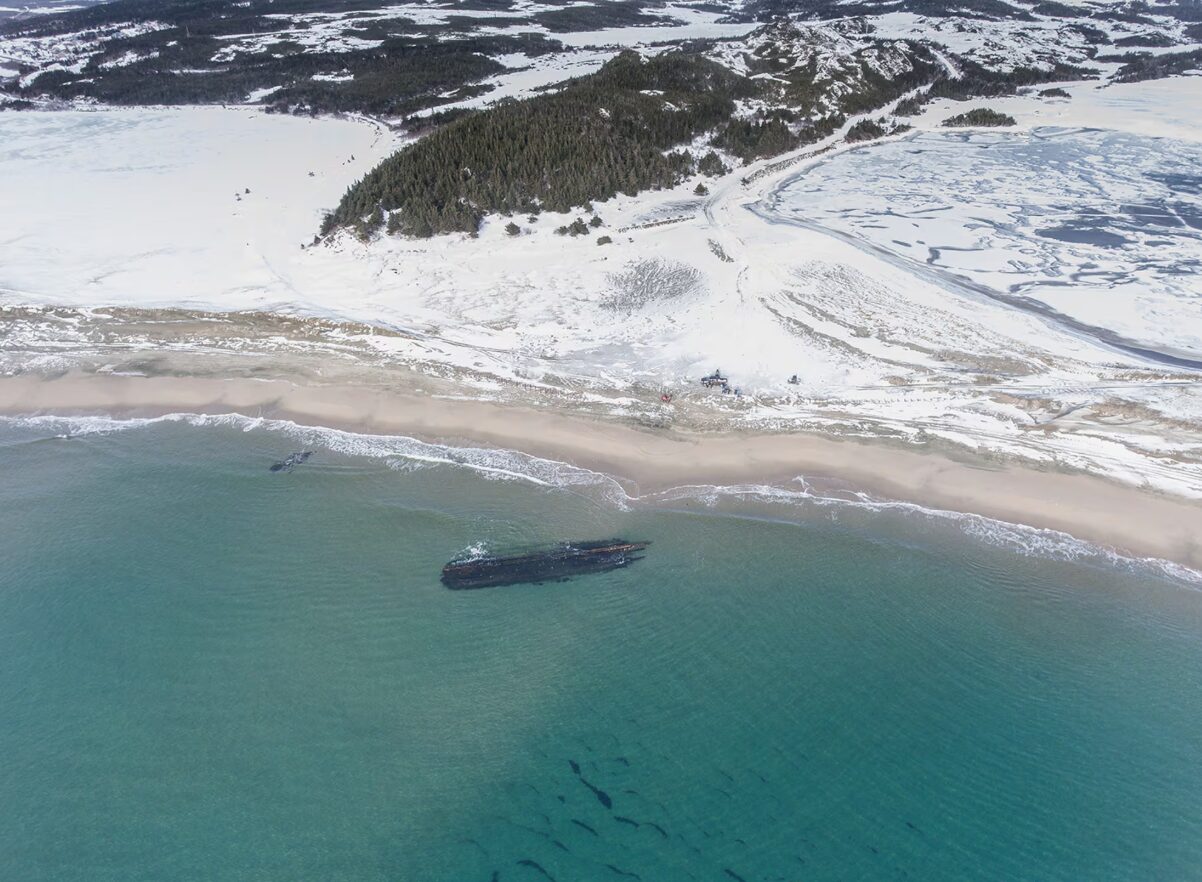 An aerial photo showing the mystery Newfoundland beach shipwreck. The overturned hull of the ancient ship appeared along Newfoundland's southwestern tip in 2024.