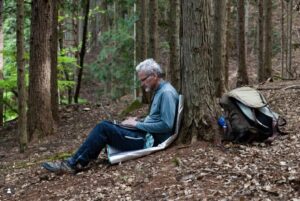 Paul Salopek writing in a forest campsite in Takato Machi, Japan in 2025
