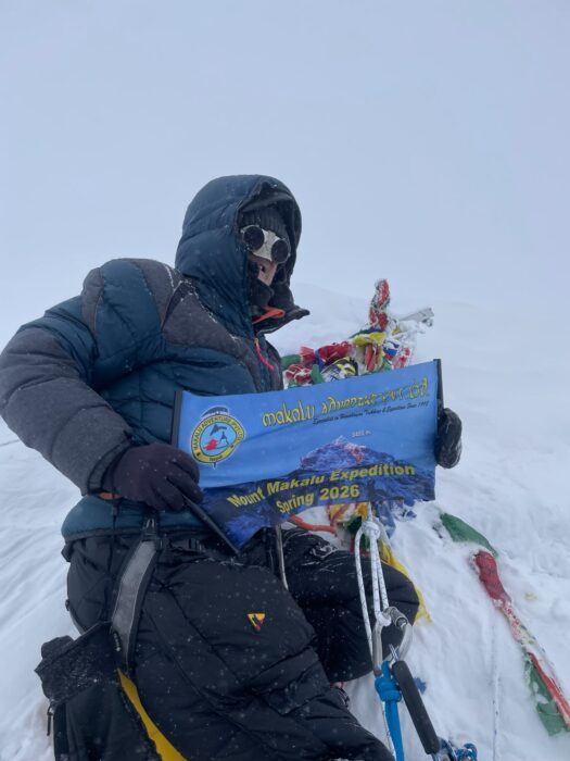 Close shot of a climber on the summit of Makalu in a cloudy day. 