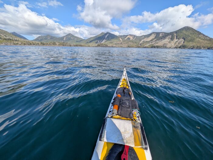 A kayak points towards the coastline of Moresby Island, British Columbia
