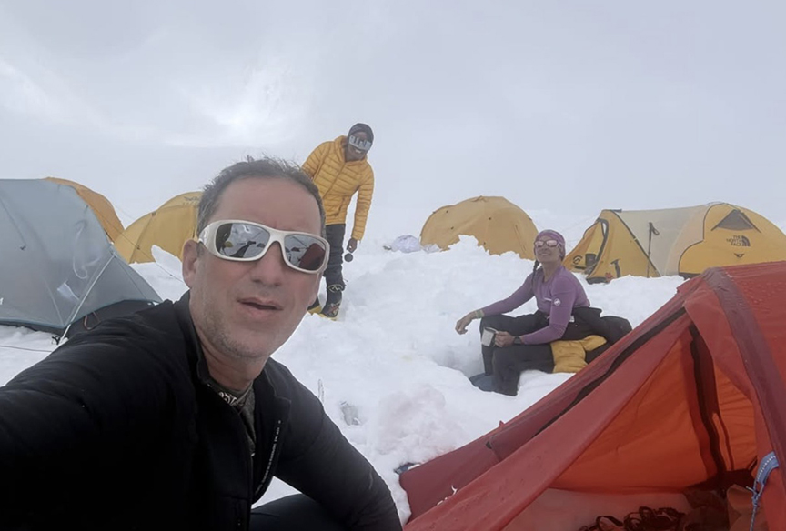 selfie of guy in sunglasses in snowy camp