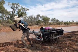 man hauling wheeled cart across Australia