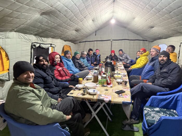 Climbers around a table in a mess tent at Gasherbrums' Base Camp. 