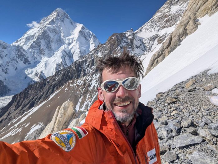 Ian Overton takes a selfie at Base Camp on Broad Peak, with K2 in background.