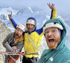 Climbers put faces as they take a selfie on a summit.