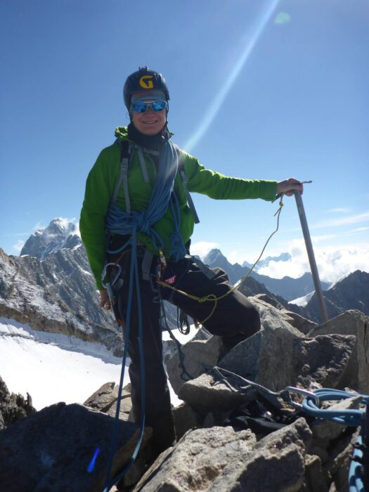 Close shot of a climber with helmet and an ice axe. 