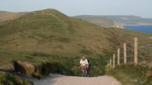 A man bicycling over rolling hills