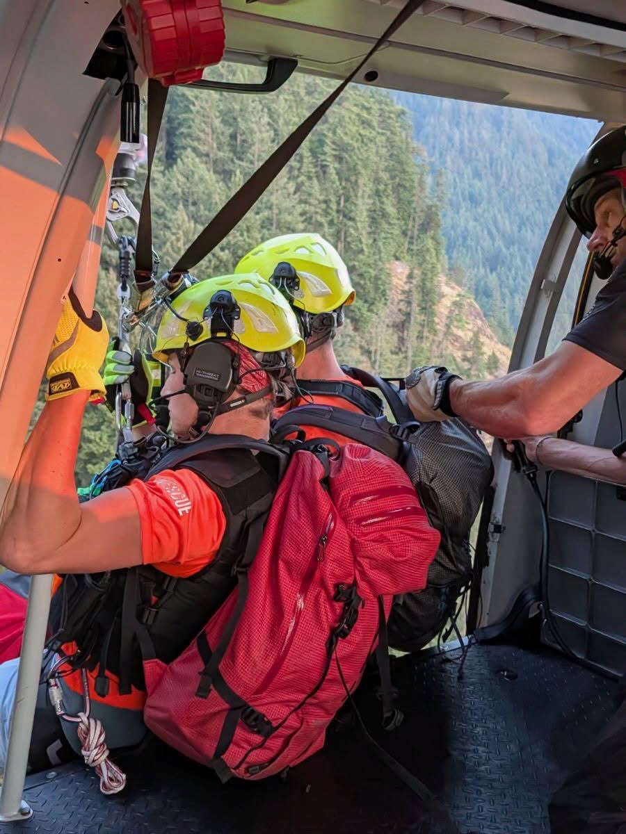 The search and rescue team working to hoist the woman from the mountain. 