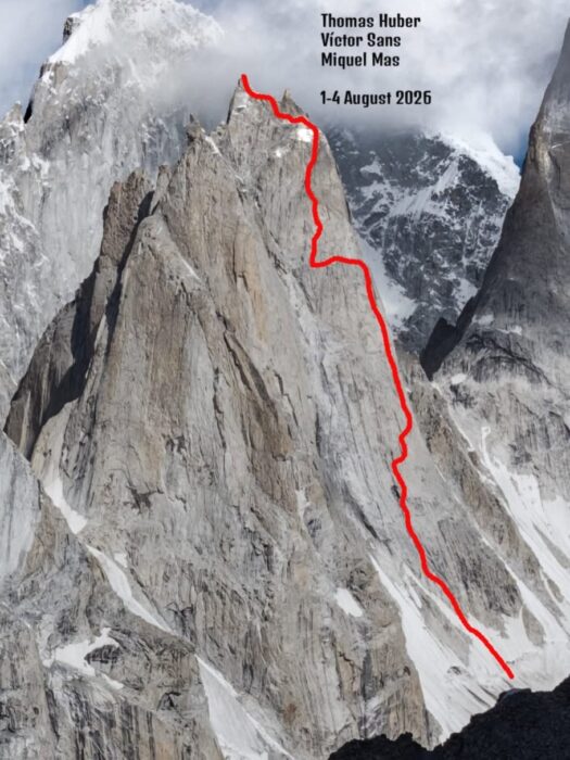 A route marked in red on a photo of a rocky spire. 