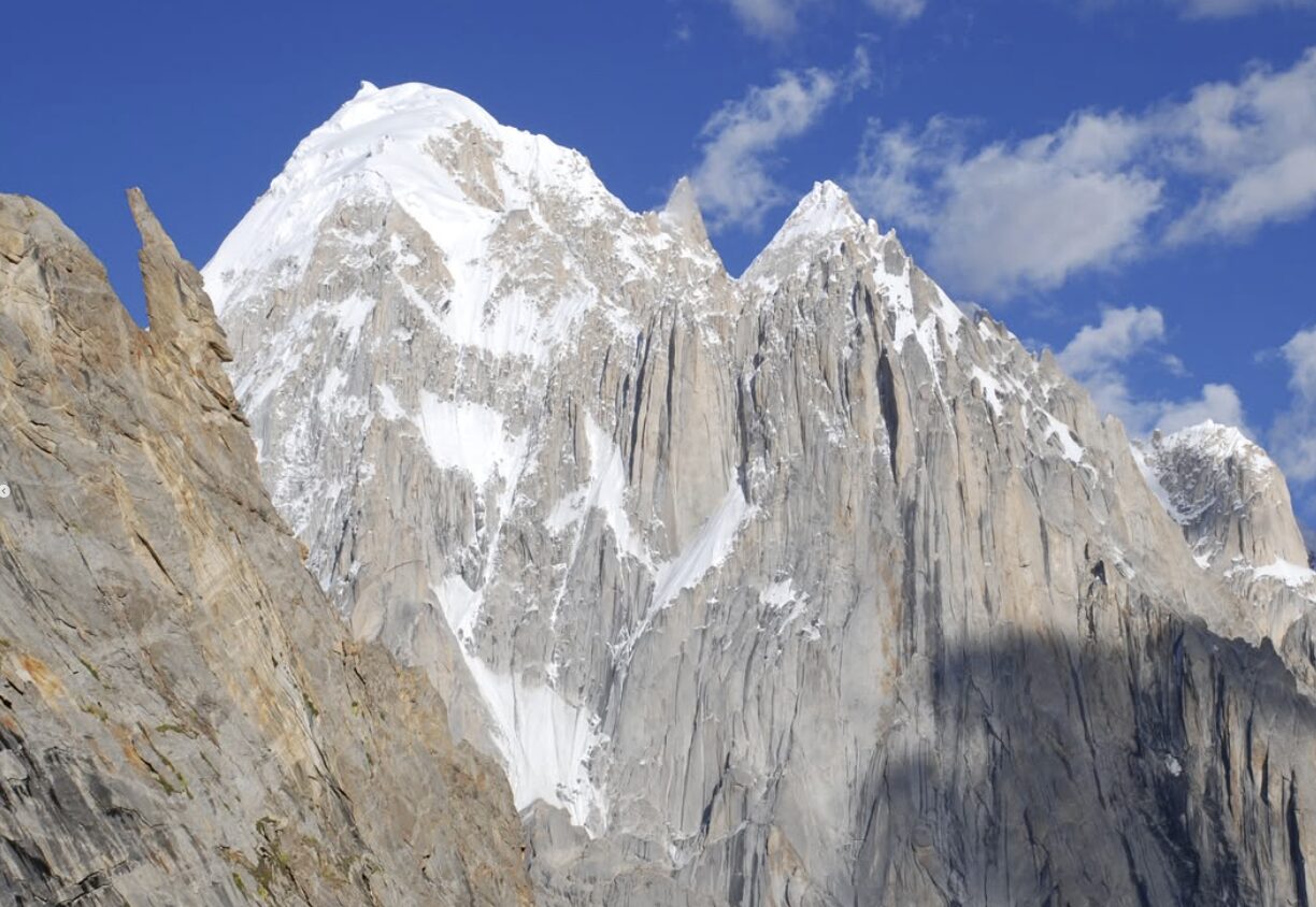 A mighty peak of vertical rock walls with an ice cap.