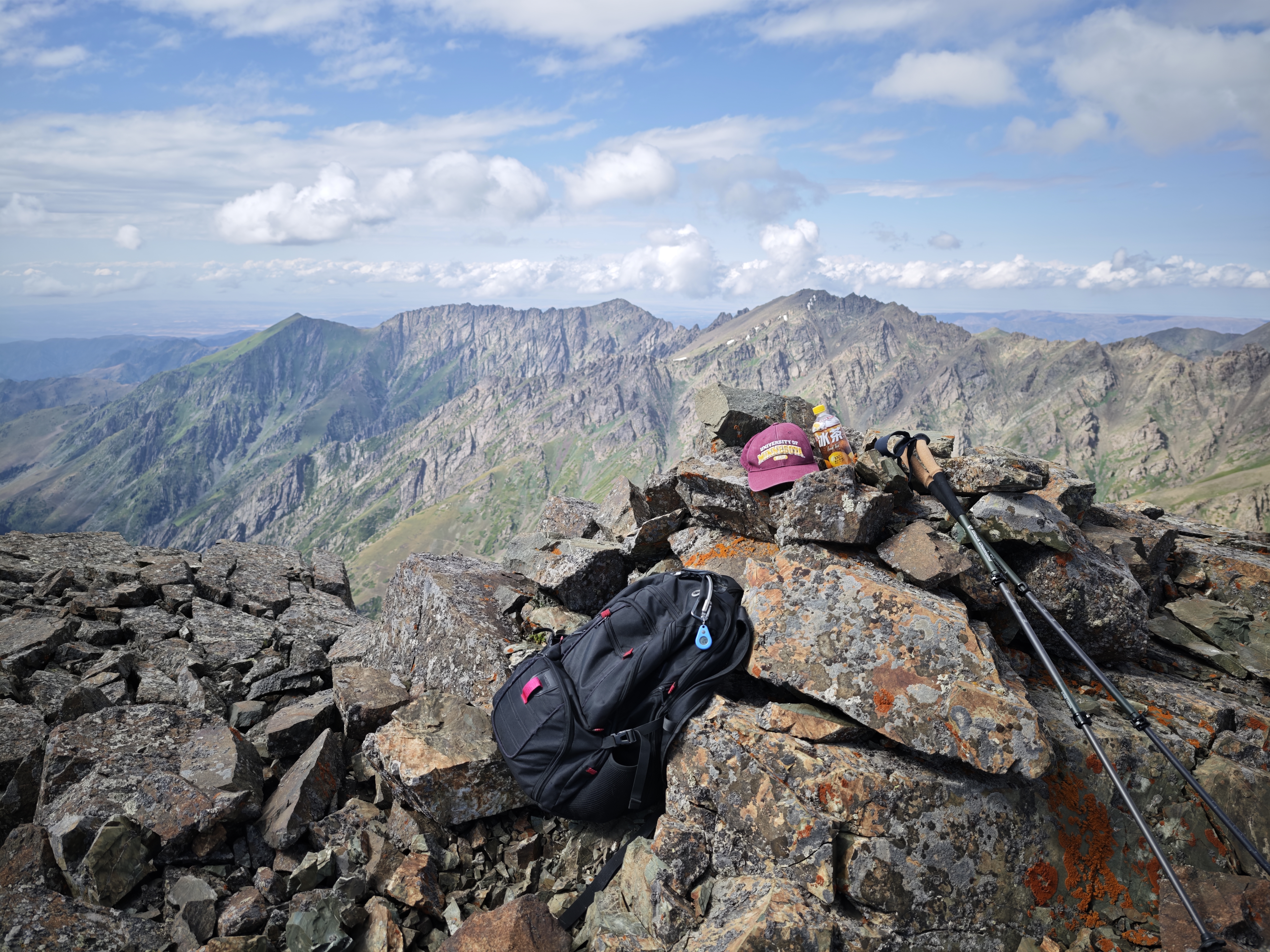A rocky summit among other similar mountains.