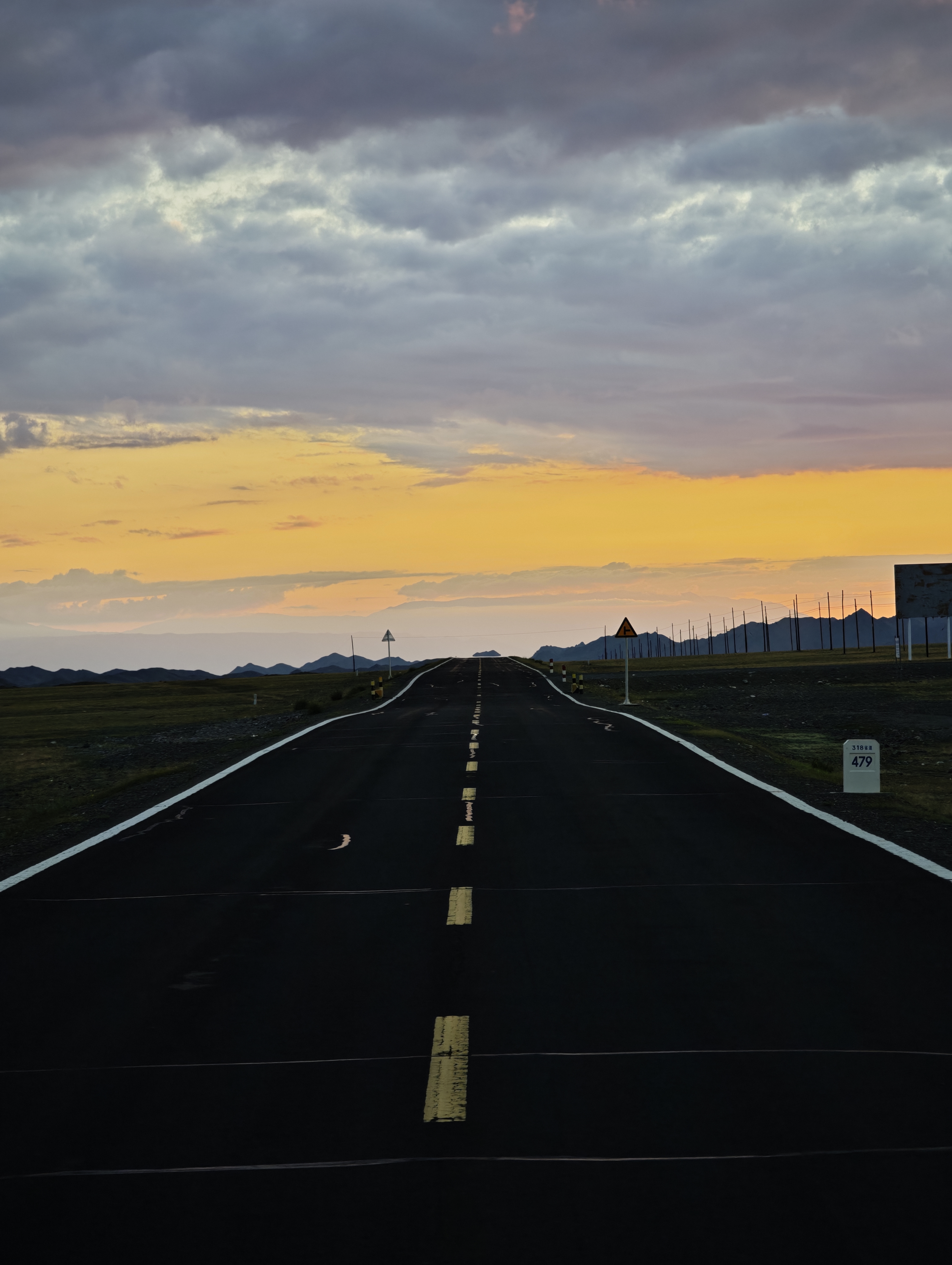 A road in a wide area at sunset.