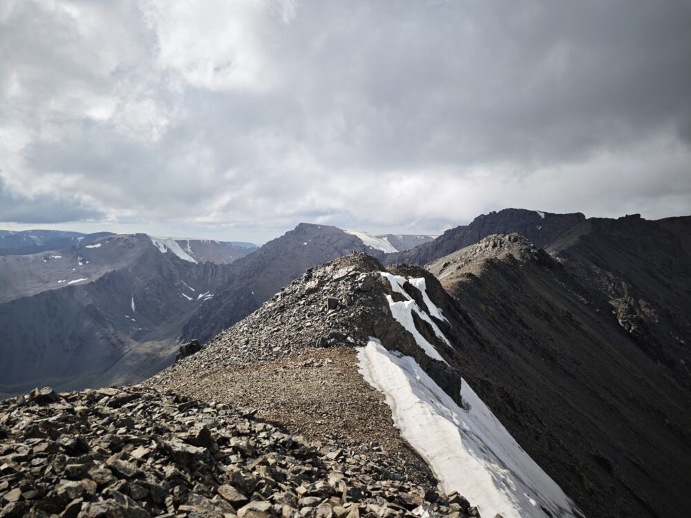 A rocky risge with some snow remaining on its shady flank.