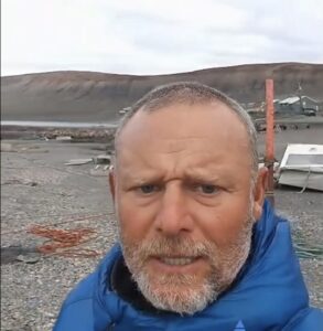 head and shoulders portrait of an older man in a blue jacket